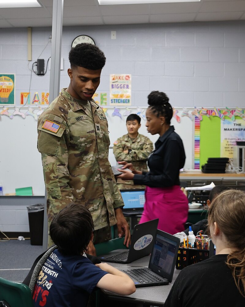 A U.S. Army Field Artillery officer working alongside students and a teacher in a Lawton Public Schools maker space.